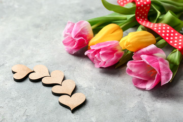 Beautiful tulips and decorative hearts on grey textured background