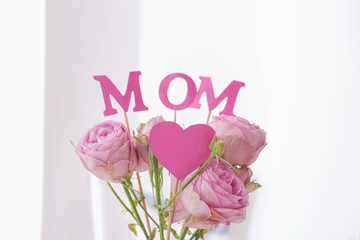 Beautiful bouquet with word MOM on light background. Mother's day celebration