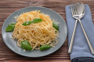 Plate with spaghetti and basil on table. Delicious pasta recipes