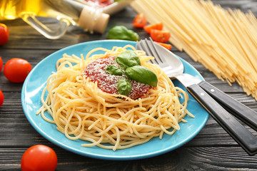 Plate with spaghetti and sauce on table. Delicious pasta recipes