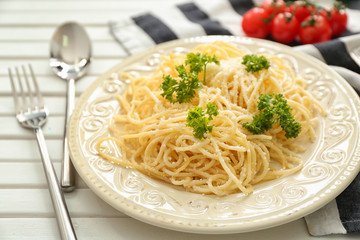 Plate with spaghetti and cheese on table. Delicious pasta recipes