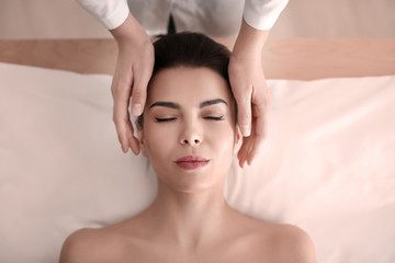 Naklejka premium Young woman enjoying facial massage in spa salon