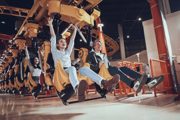 Happy young people ride on attractions.