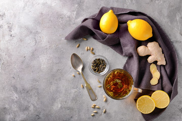 Flat lay composition with cup of hot tea, lemon and ginger on table