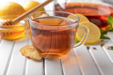 Cup of hot tea with lemon and ginger on wooden table