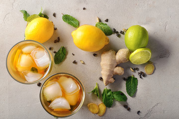 Flat lay composition with glasses of cold lemon tea and ginger on table