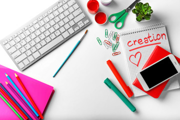 Computer keyboard, smartphone and stationery on white background, flat lay. Workplace table composition