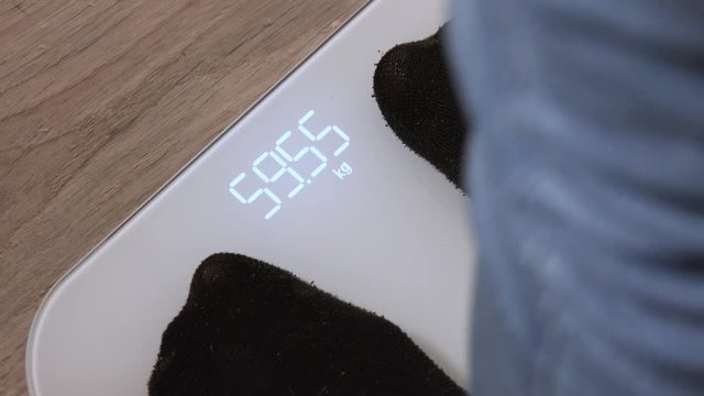 A woman stands on a digital scale - closeup
