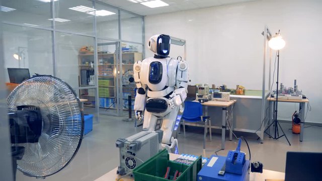 A robot raises its arm and turns.