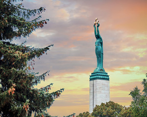 Monument of freedom in Riga. Woman holding three gold stars which symbolise three regions of Latvia. - obrazy, fototapety, plakaty