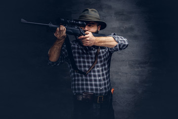 Hunter aiming a rifle in sight while preparing to make an accurate shot at the prey.