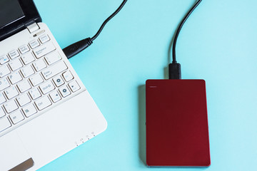 Modern laptop keyboard and storage, external hard drive for many data information on pastel color...