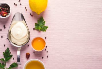 Mayonnaise sauce and ingredients on pink cloth background