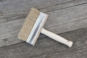 Brush for dyeing at old uncoated wooden household background for painting