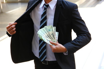 business man in suit show his dollars in his hand
