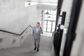 business people, technology and corporate concept - businessman calling on smartphone at office