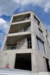 Fototapeta premium Immeubles en cours de construction, béton brut et ciel bleu.