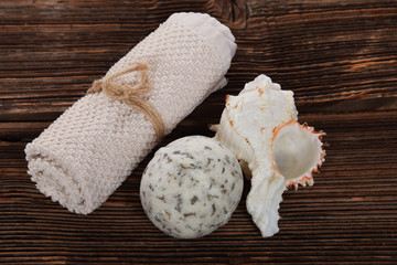 white towel and herbal white bath ball in a bathtub on a brown background