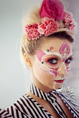 Young beautiful woman with skull makeup. Mexican day of the dead