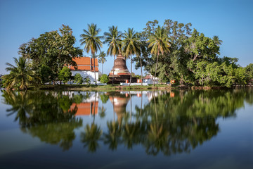 Fototapeta na wymiar un temple bouddhiste qui ce reflète sur un étang dans le parc historique de sukhothai 