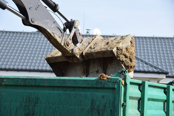 earth with clay transferred by a digger to a tractor