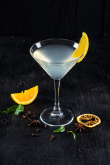 Alcohol transparent cocktail with ice and lemon on black background