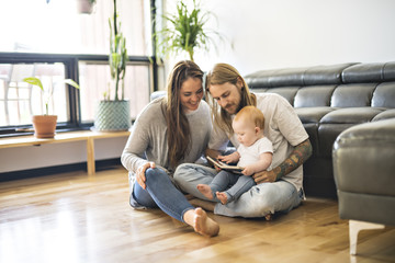 family with her baby and a book in the living room