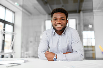 business and people concept - smiling african american businessman at office