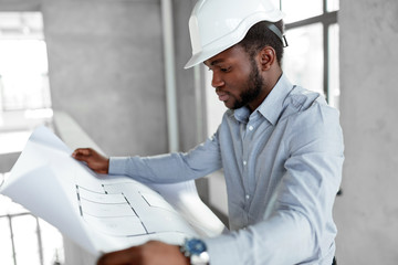 architecture, construction business and people concept - african american architect in helmet with blueprint