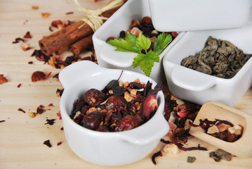 different types of tea dried in ceramic white containers, green tea, fruit tea, rose tea