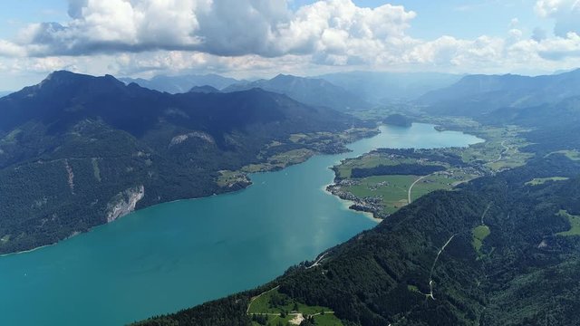 Aerial panoramic view of lake Wolfgangsee in summer, beautiful scenery with majestic lush green slopes and peaks of Alps mountains - picturesque landscape of Austria from above, Europe 