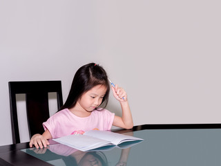 Asia little student girl studying and doing his homework  at home,  on the table, home education