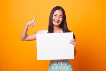Fototapeta premium Young Asian woman show thumbs up with white blank sign.
