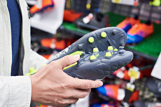 Hands of man with football boots in sport store