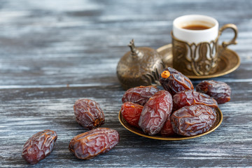 Dates on the plate and black coffee.