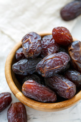 Dried fruits of date palm in a wooden bowl.