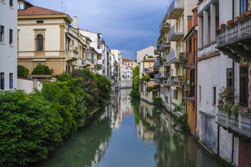 Fototapeta na wymiar Padova, Italy - May, 6, 2018: Houses on a bank of channel in Padova