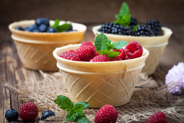 Blackberries, raspberries and blueberries in a waffle bowls.