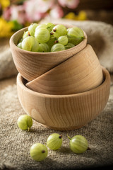 Fresh gooseberry in a wooden bowl.