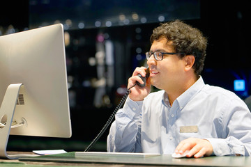 Hotel administrator. A male-reception worker accepts an order for booking a room by phone. Profile...