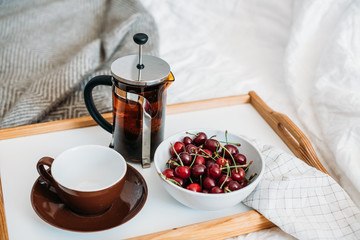 Fresh healthy vegan breakfast in bed, green tea and cherry in mo