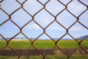 Naklejka premium Chain link fence with grass field Phuket International Airport