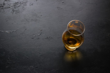 a glass of whiskey on a black background with space for text