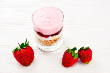 Home made granola breakfast with strawberries and plain yogurt, served in the glass.