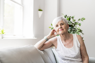 Portrait of a Cheerful senior Woman Sitting on the Sofa in the Living Room