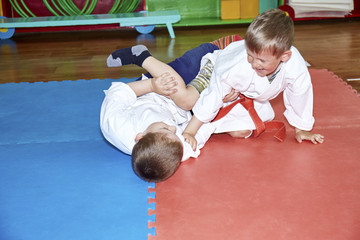 On the mats, two athletes practice sparring