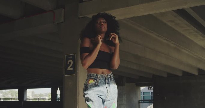 Portrait of young woman smiling and playing with glasses in urban city environment  