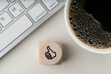 Würfel mit Daumen-Hoch-Symbol am Arbeitsplatz 