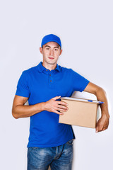 Cheerful delivery man. Happy young courier holding a cardboard box and smiling
