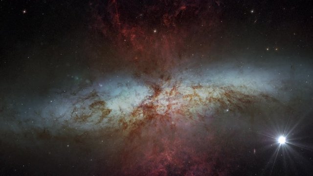 Starburst galaxy Messier 82 slow rotating with flying stars and lights in outer space, 3D animation. Contains public domain image by NASA